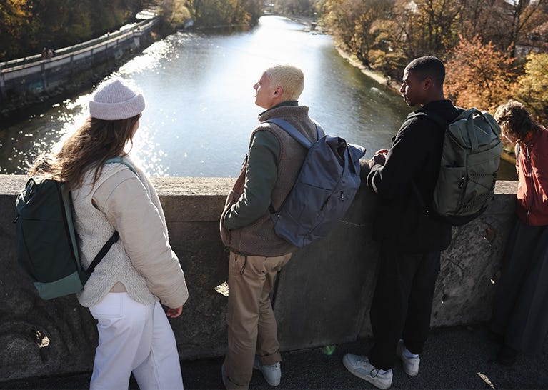 Zeit mit Freunden verbringen Freundesgruppe steht mit eoto Rucksäcken auf einer Brücke