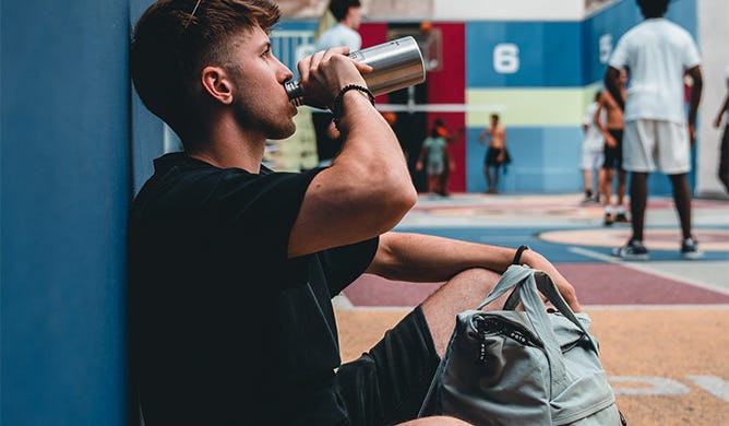 Daypack von eoto Sportler nimmt Flasche aus seinem eoto Daypack zum Trinken