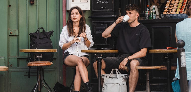 Personen mit eoto-Rucksack trinken Kaffee 